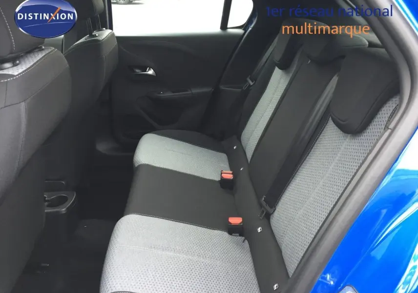 Vue côté droit de l'habitacle arrière d'une Opel Corsa bleu voltaik metal, avec sièges tissu bicolore gris et noir.