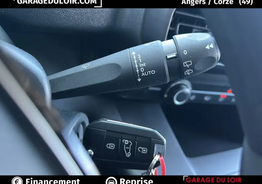 Gros plan sur la commande d'essuie-glace et la clé noire du Peugeot Rifter 2024 dans l'habitacle.