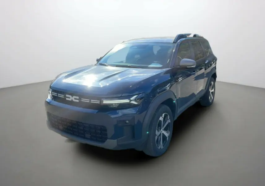 SUV Dacia Bigster bleu indigo en 3/4 avant droit avec barres de toit et jantes alu 18 pouces visibles