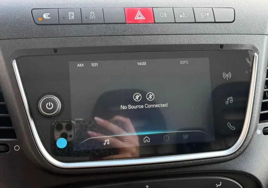 Gros plan sur l’écran tactile et la rangée de boutons de commande du tableau de bord du fourgon Iveco Daily blanc.