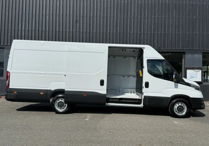 Vue latérale droite d’un Iveco Daily blanc 2026 avec porte coulissante ouverte montrant l’espace de chargement vide.