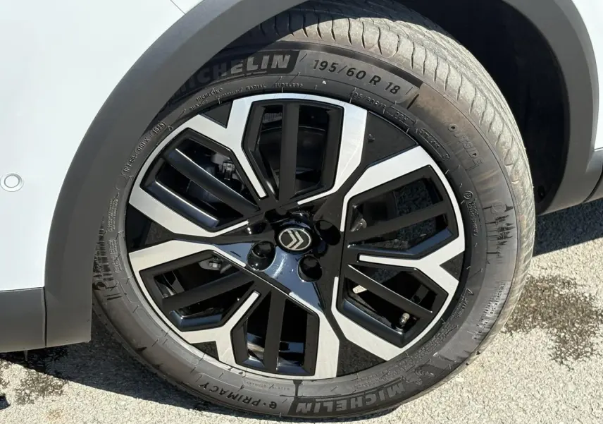 Gros plan sur la jante alliage 18'' diamantée noire et argentée du Citroën C4 Hybrid blanc Okénite.
