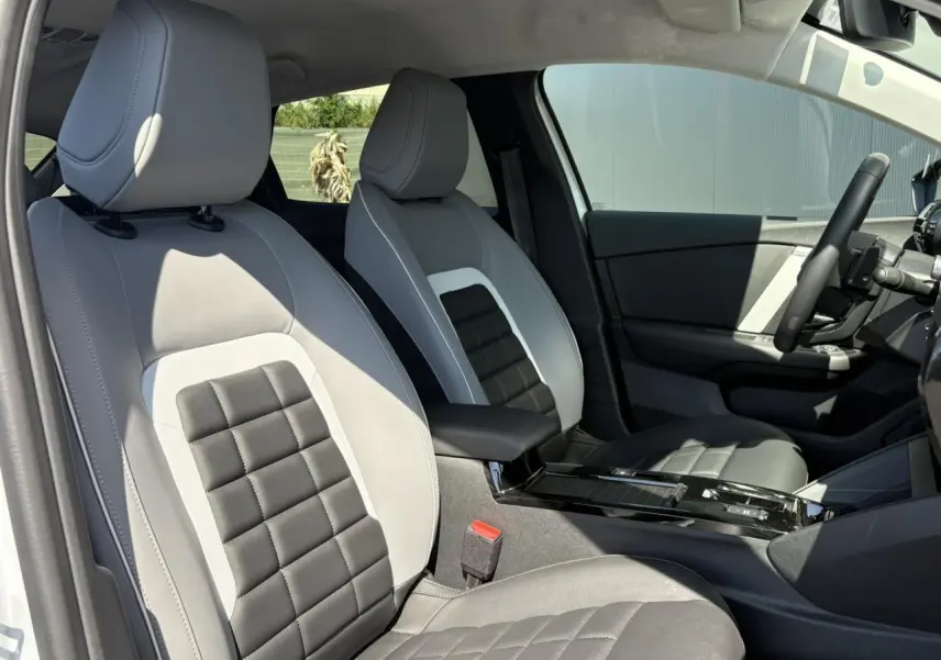 Vue intérieure côté conducteur de la Citroën C4 Hybrid 145 e-DSC6 Max avec sièges bicolores gris clair et noir.