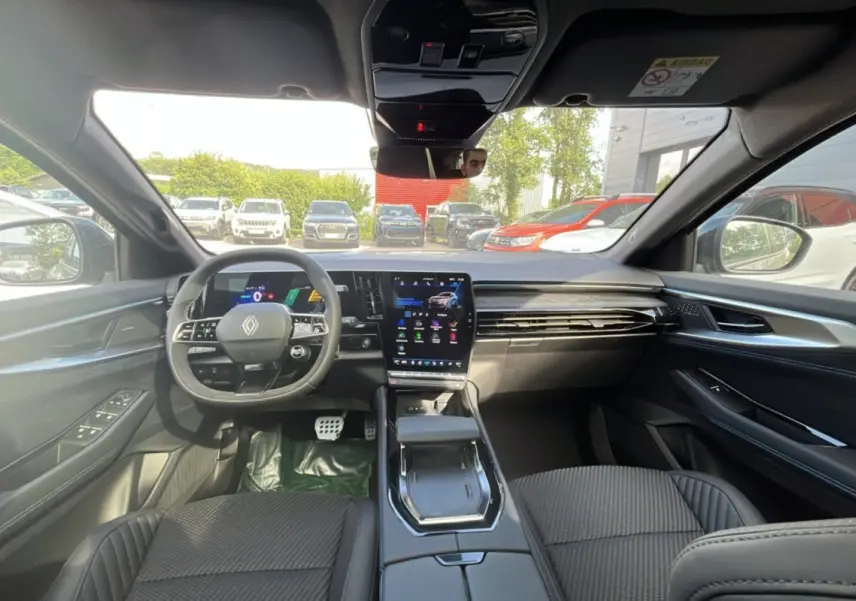 Vue intérieure avant du Renault Austral 200 Esprit Alpine, tableau de bord moderne avec écran tactile vertical et volant multifonctions.