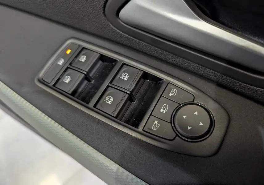 Commande des vitres électriques et réglage des rétroviseurs sur la porte côté conducteur du Dacia Duster gris Schiste.