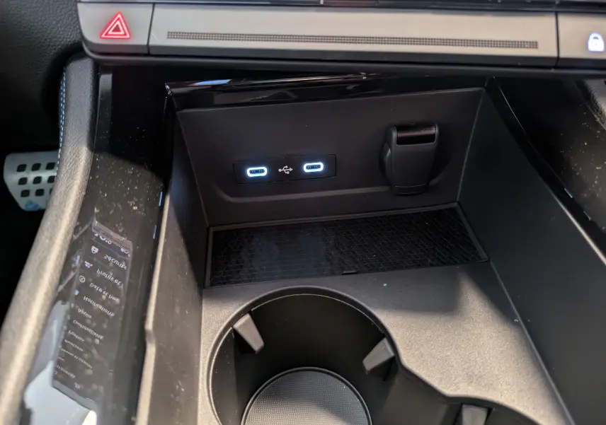 Gros plan sur la console centrale noire du Renault Espace VI avec ports USB éclairés et prise 12V visible.