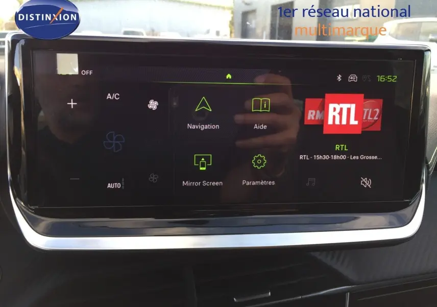 Écran tactile central du Peugeot 208 gris Artense, affichant les options de navigation, aide et radio RTL.