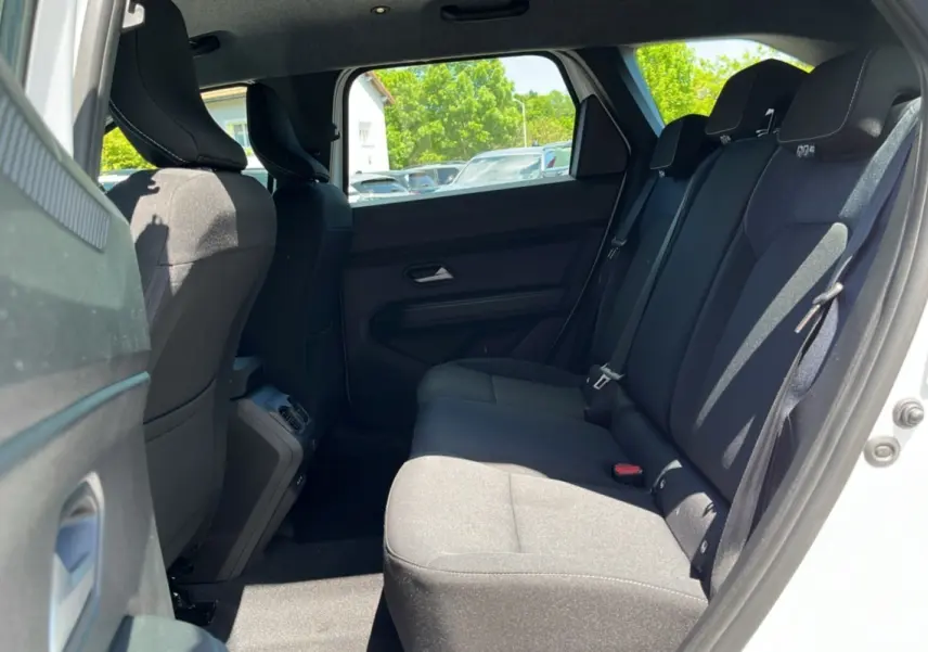 Vue latérale droite de l'habitacle arrière du Dacia Bigster blanc glacier, montrant les sièges noirs et l'ouverture de porte.