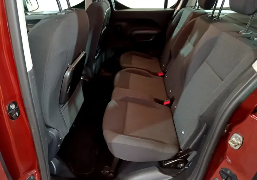 Vue côté droit sur les sièges arrière gris du Peugeot Rifter marron, porte ouverte et intérieur spacieux visible.