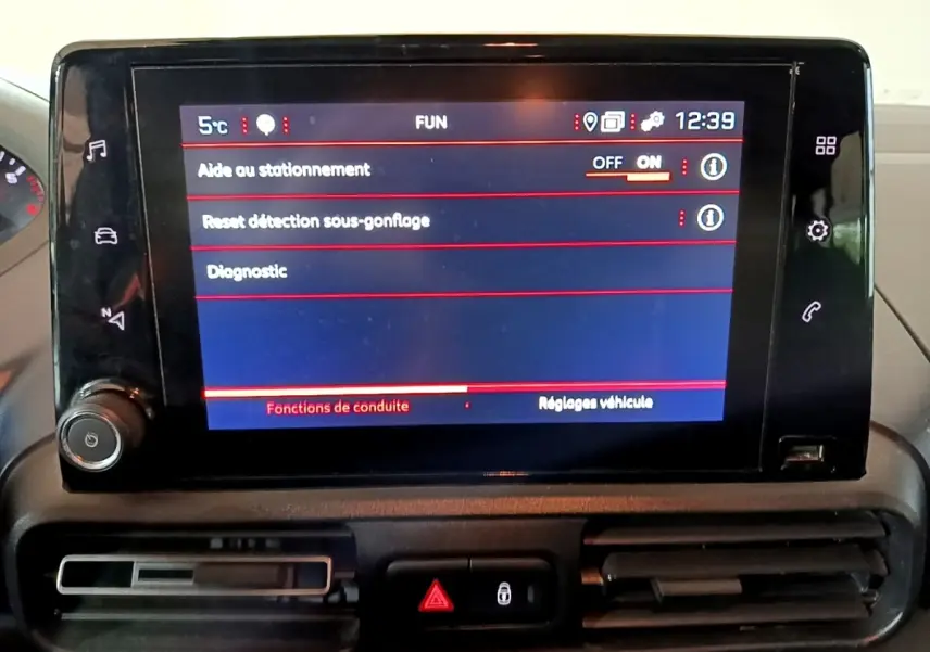 Écran tactile central du tableau de bord du Peugeot Rifter marron 2019 affichant les réglages d'aide au stationnement.