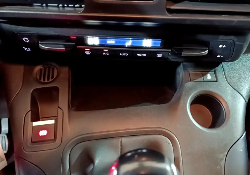Détail de la console centrale noire du Peugeot Rifter BlueHDi 100 Allure 2019 avec frein à main électrique et commandes climatisation.