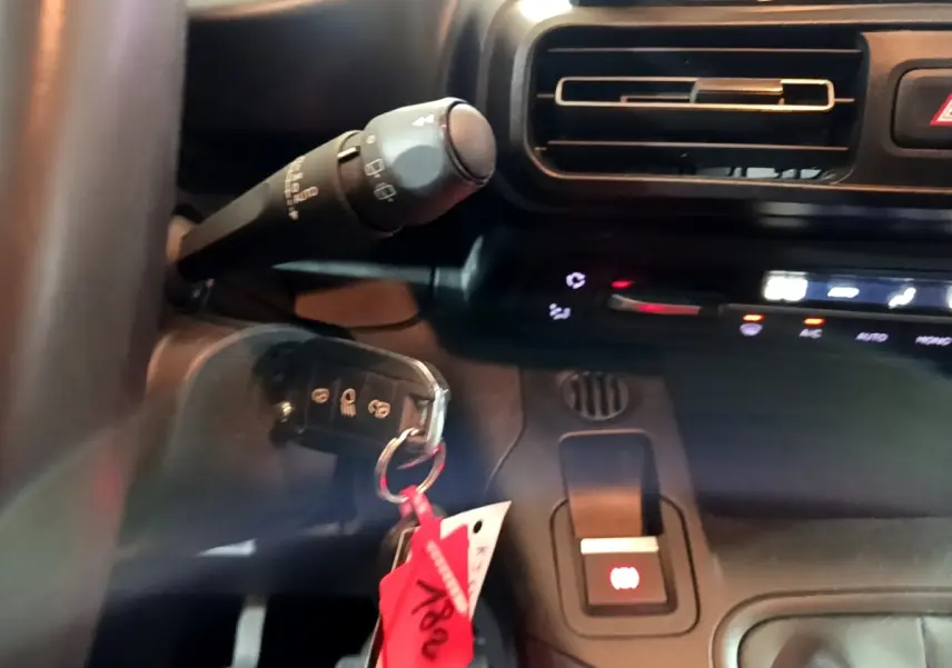 Gros plan sur la commande de frein à main électrique et clé de contact dans l'habitacle noir du Peugeot Rifter Marron 2019