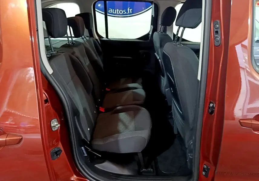 Vue intérieure sur la banquette arrière noire du Peugeot Rifter marron 2019, porte latérale ouverte côté droit.