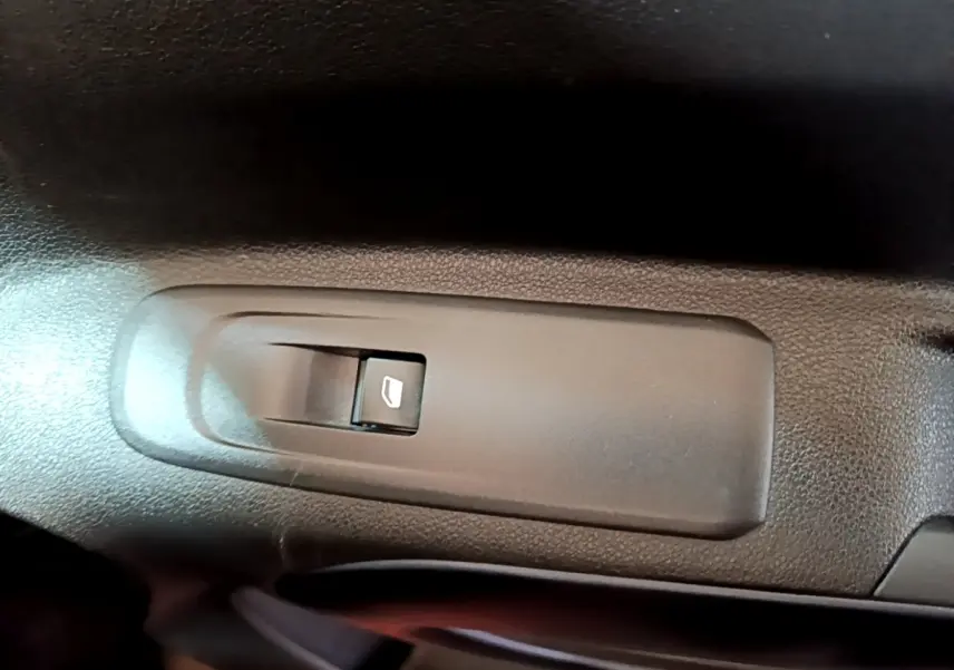 Bouton de commande de lève-vitre électrique côté conducteur dans l'habitacle du Peugeot Rifter marron 2019.