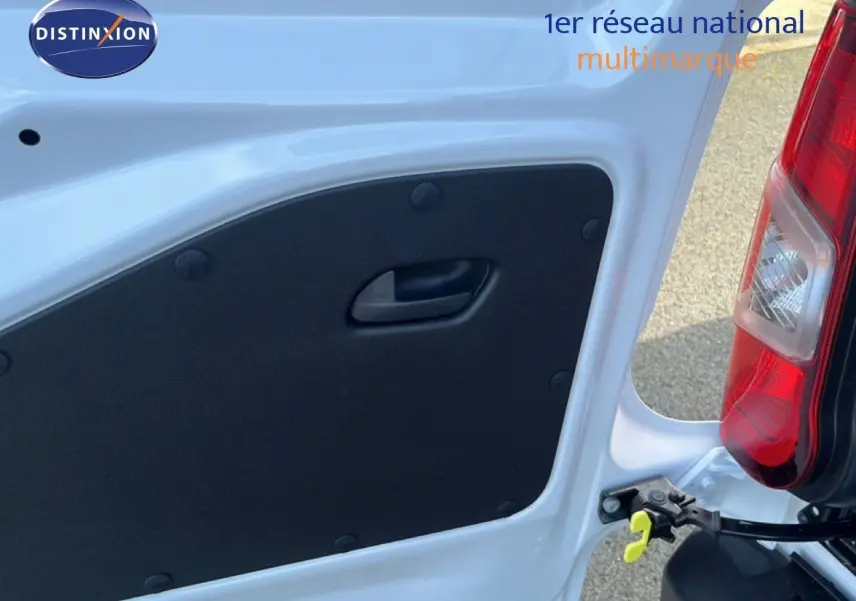 Gros plan sur l’intérieur de la porte arrière droite blanche du Citroën Berlingo 2025, avec poignée noire et feu arrière visible.