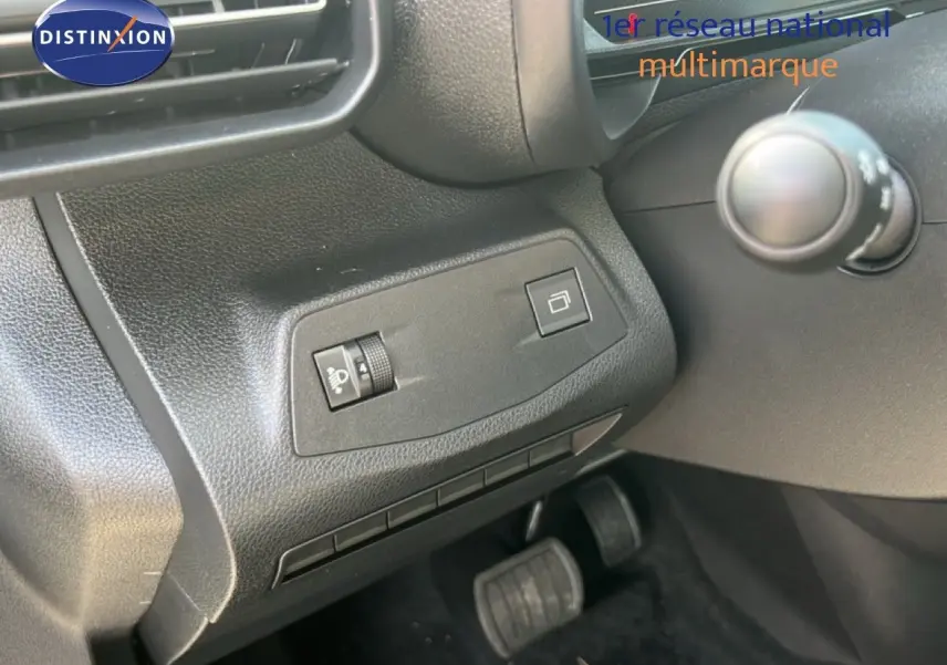 Détail de la console côté gauche avec commandes d’éclairage et rétroviseur, pédales visibles, intérieur noir du Citroën Berlingo 2025.