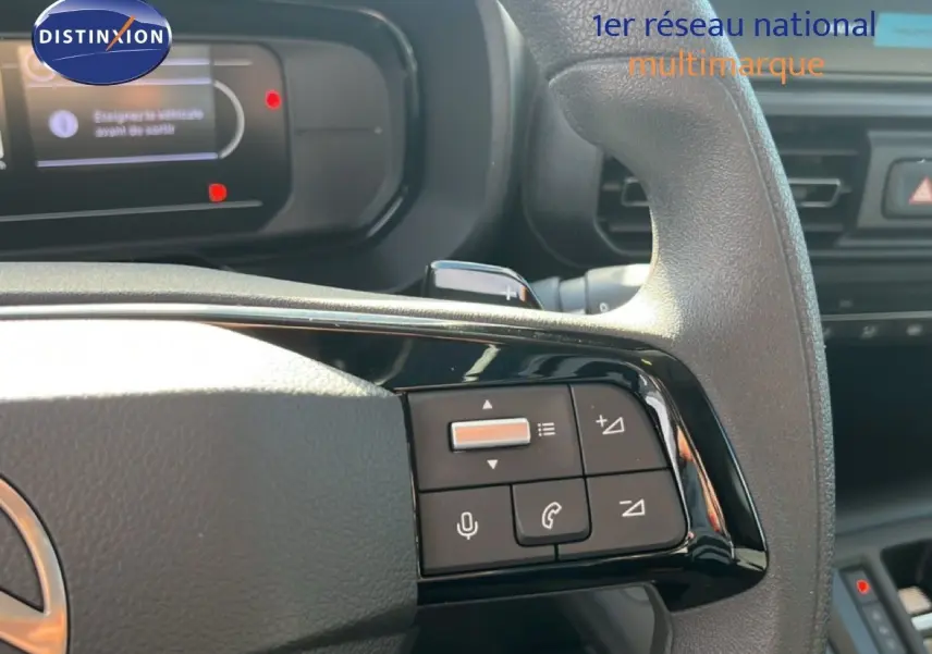 Gros plan sur le volant multifonction du Citroën Berlingo 2025, mettant en valeur les commandes audio et téléphone.