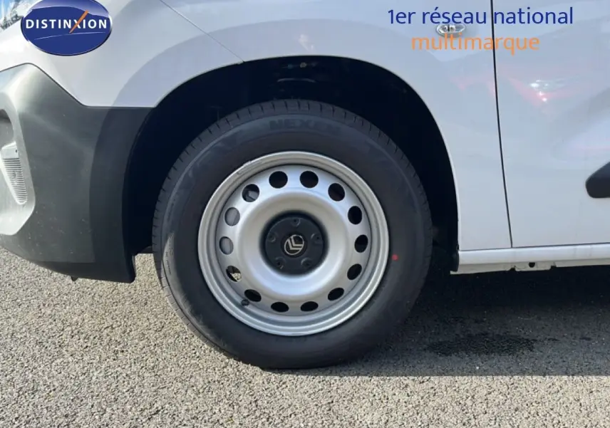 Gros plan sur la roue avant gauche d’un Citroën Berlingo blanc Icy, avec jante acier et logo Citroën central.