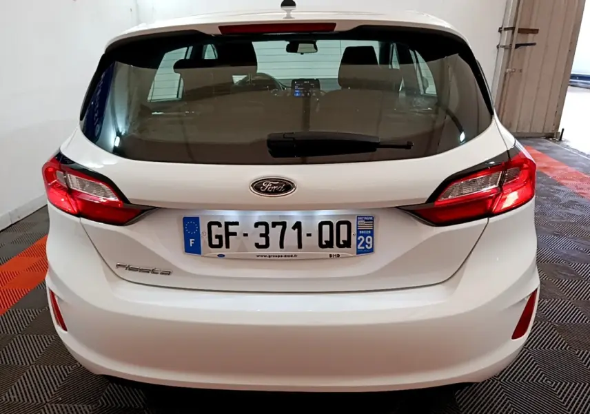 Vue arrière d'une Ford Fiesta blanche 2022 avec feux arrière LED et plaque d'immatriculation française visible.