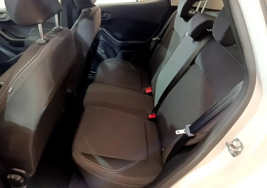 Vue intérieure côté droit montrant la banquette arrière noire de la Ford Fiesta blanche 2022, avec ceintures de sécurité visibles.