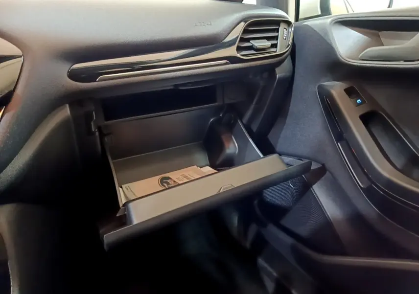 Intérieur de la Ford Fiesta 2022 blanc, vue côté passager sur boîte à gants ouverte et porte avec commande de vitre.