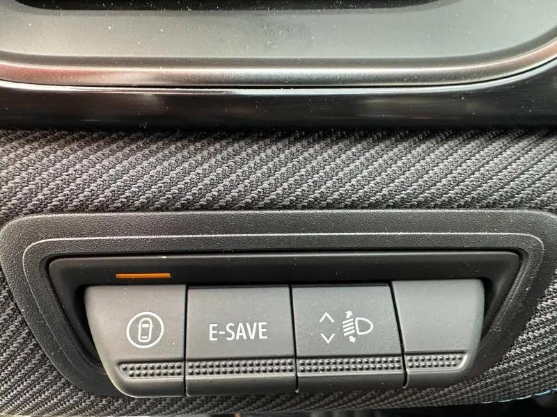 Gros plan sur les boutons de commande intérieurs du Renault Captur 2026, finition Esprit Alpine, avec tissu noir texturé.