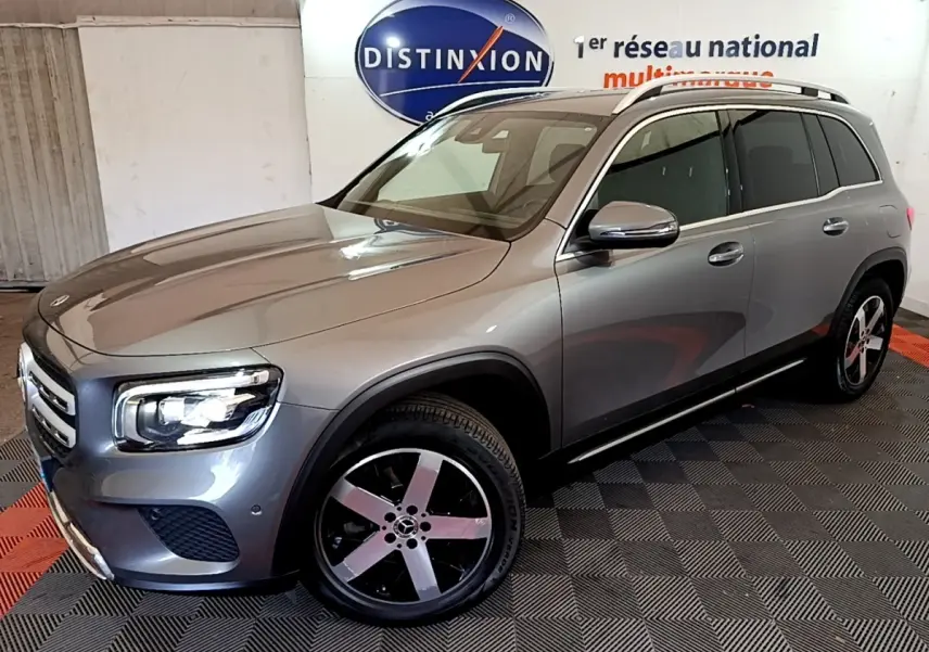 Mercedes GLB 200 d Business Line gris foncé en 3/4 avant droit, avec jantes alliage et barres de toit chromées.