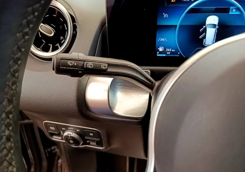 Gros plan sur la commande d’essuie-glace à gauche du volant d’un Mercedes GLB 200 d Business Line, intérieur noir.