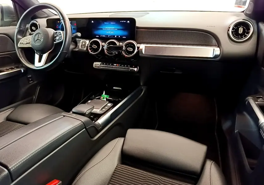 Intérieur noir du Mercedes GLB 200 d 2021 vu côté conducteur, avec tableau de bord digital et volant cuir alu.