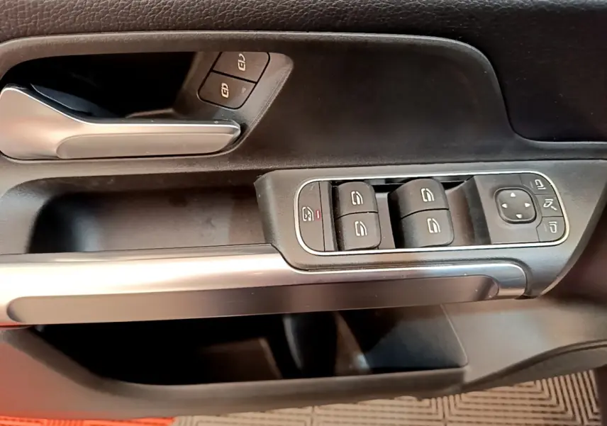 Gros plan sur la porte côté conducteur du Mercedes GLB 200 d Business Line 2021, avec commandes vitres et poignée alu.