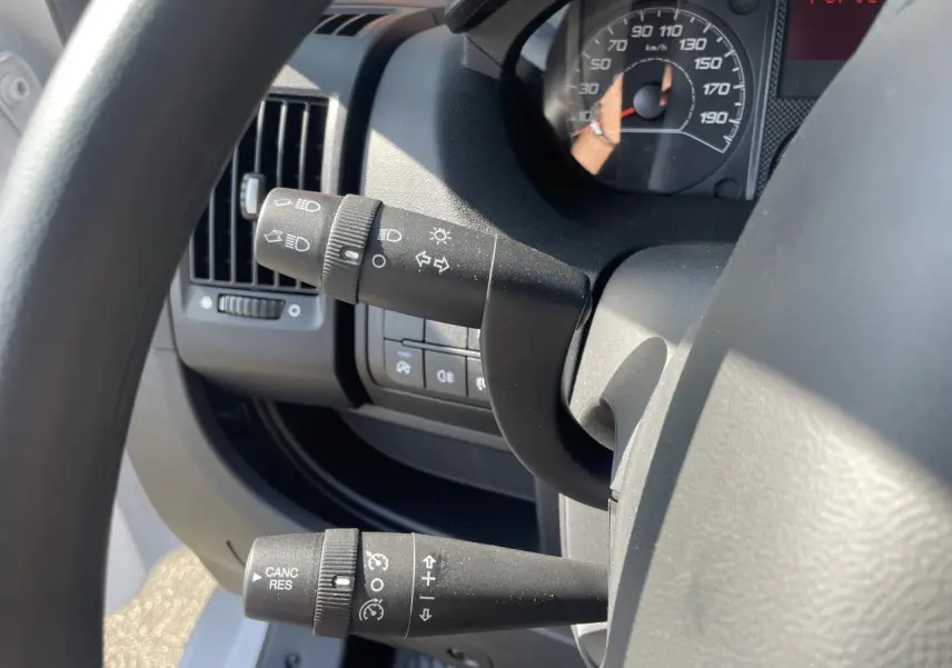 Vue rapprochée du volant et des commandes de régulateur de vitesse du Citroën Jumper blanc, avec tableau de bord partiel visible.