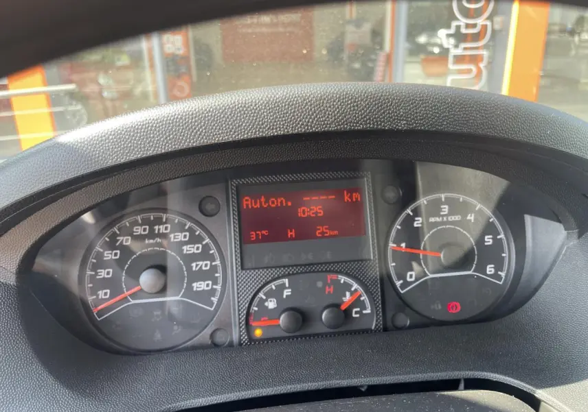 Vue rapprochée du tableau de bord du Citroën Jumper 2023, affichage digital rouge et compteurs analogiques noirs.