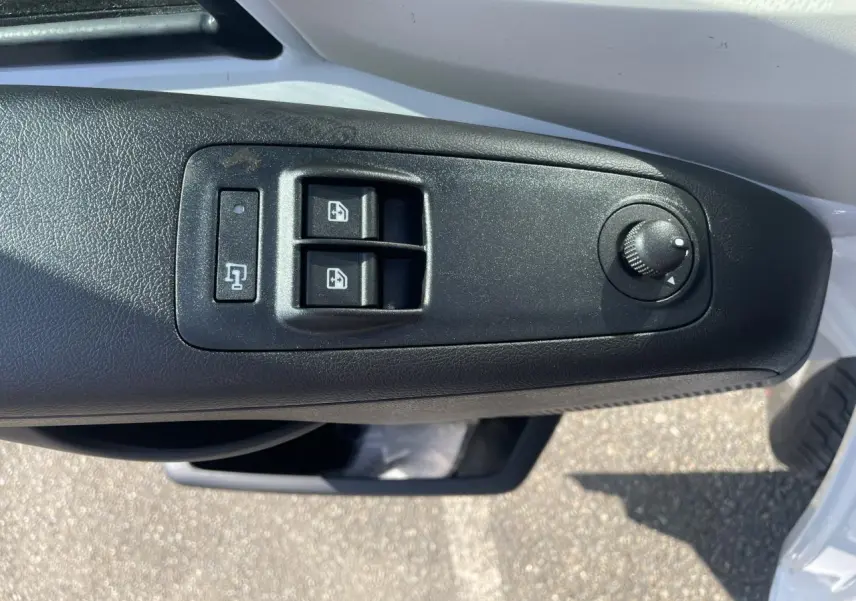 Gros plan sur les commandes de lève-vitres et réglage des rétroviseurs côté conducteur du Citroën Jumper blanc 2023.