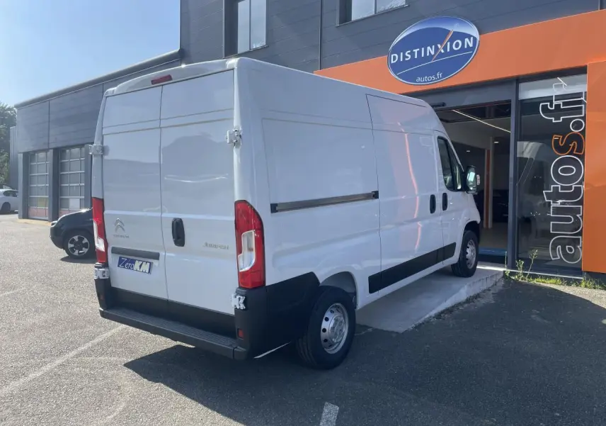 Vue 3/4 arrière droite d’un utilitaire Citroën Jumper blanc avec portes arrière tôlées et porte latérale coulissante.