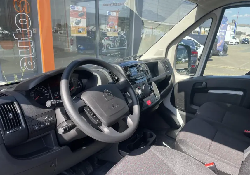 Vue intérieure côté conducteur du Citroën Jumper blanc 2023, montrant le volant, tableau de bord et banquette passager biplace.