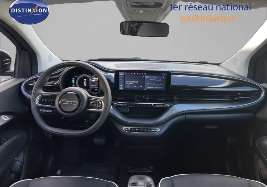 Vue intérieure frontale du tableau de bord noir onyx de la FIAT 500 électrique 2023 avec écran tactile et volant multifonction.