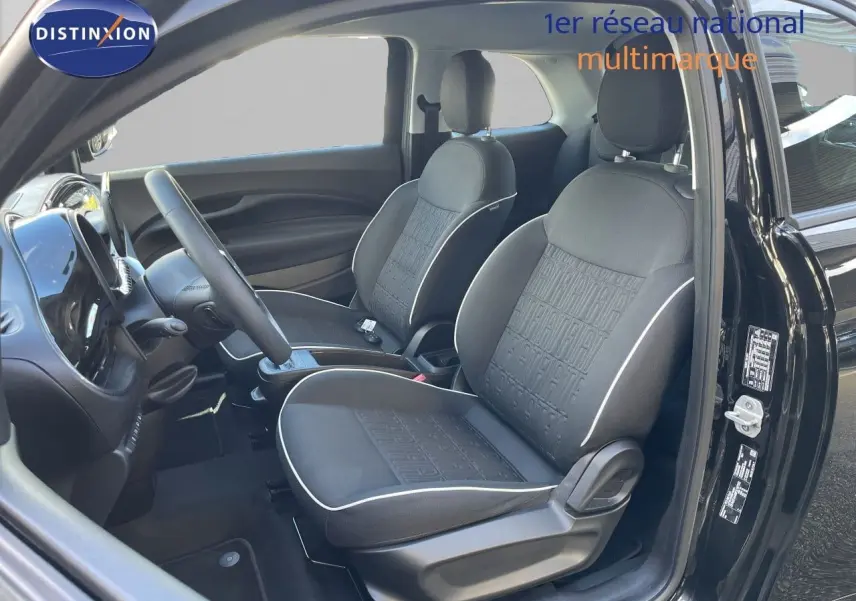 Intérieur avant droit de la Fiat 500 électrique noire Onyx 2023 avec sièges tissu noir et volant multifonction cuir.