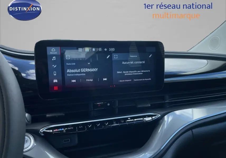 Vue intérieure du tableau de bord de la Fiat 500 électrique 2023, écran tactile central et commandes climatisation visibles.