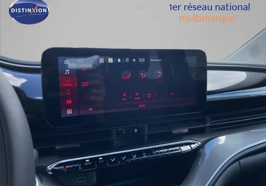 Écran tactile central de la Fiat 500 électrique 2023, affichant les réglages de climatisation dans un intérieur noir brillant.