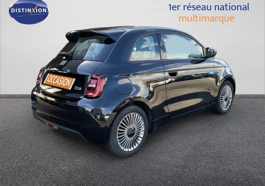 Vue 3/4 arrière droite d'une FIAT 500 électrique noir onyx avec jantes stylisées et feux arrière LED.