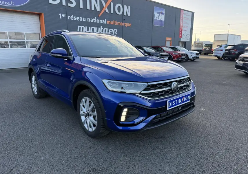 Volkswagen T-Roc 2.0 TDI R-Line bleu lapiz métallisé vu en 3/4 avant droit sur parking extérieur.