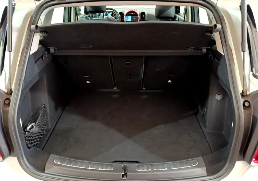 Coffre ouvert vu de l'arrière d'une MINI Countryman gris clair, avec banquette arrière et tableau de bord visibles.
