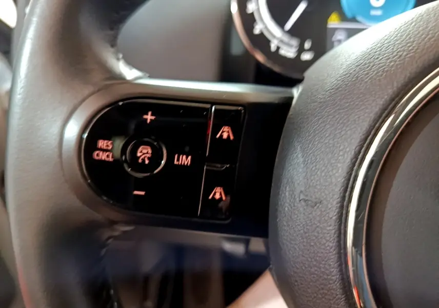 Gros plan sur les commandes de régulateur de vitesse au volant cuir du MINI Countryman gris clair 2022.