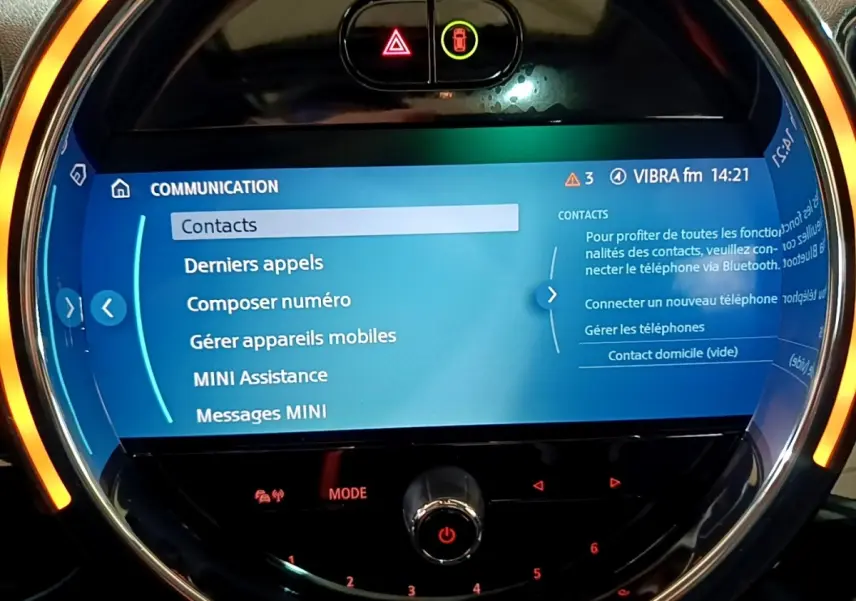 Écran tactile central rond allumé avec interface bleue, ambiance lumineuse orange, tableau de bord MINI Countryman 2022.