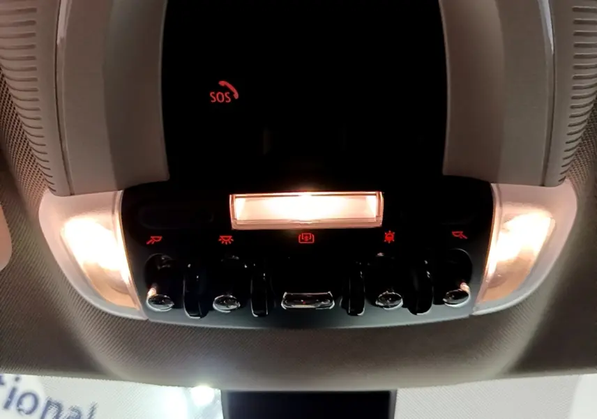 Vue en contre-plongée du panneau de commandes lumineux intérieur du toit d’un MINI Countryman gris clair 2022.