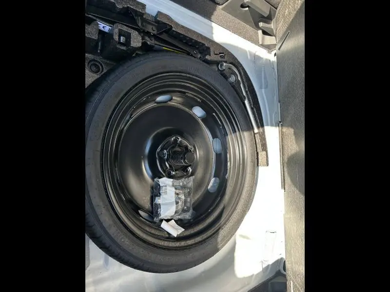 Vue rapprochée de la roue de secours noire dans le coffre du CUPRA Formentor blanc Nevada métallisé 2025.