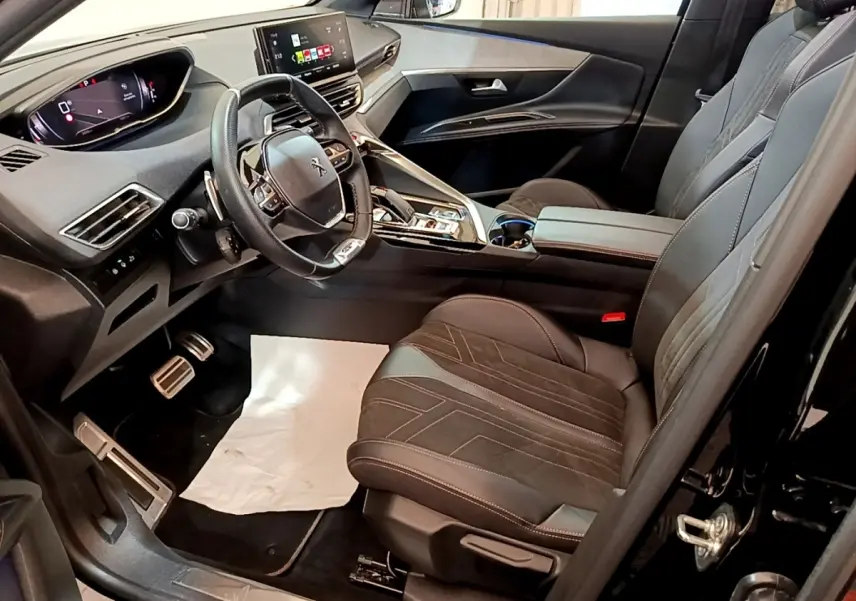 Intérieur avant droit du Peugeot 3008 GT Pack noir 2022, volant cuir alu multifonctions et tableau de bord digital.