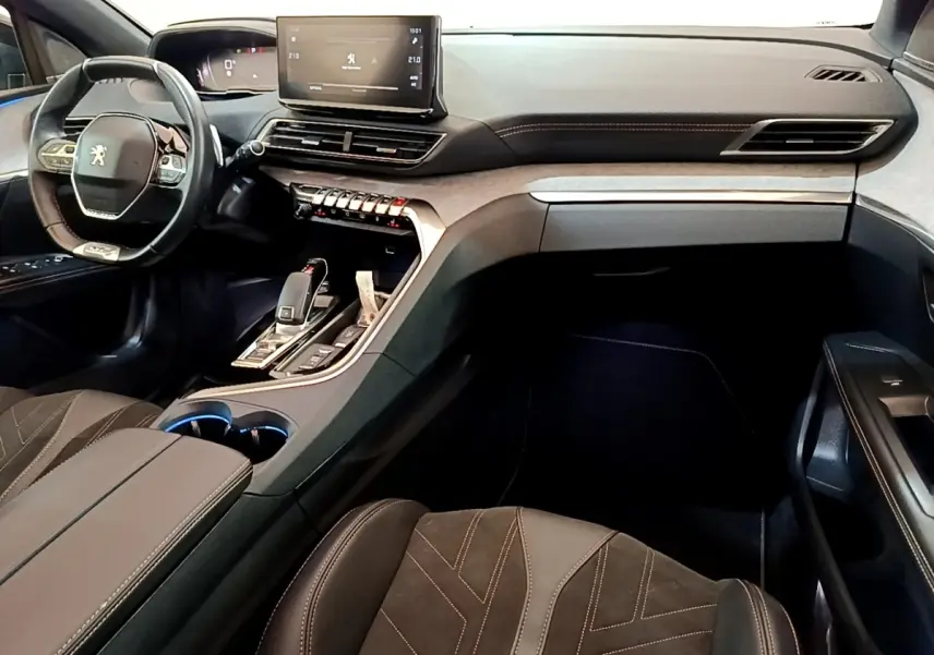 Vue intérieure avant droite du Peugeot 3008 GT Pack 2022 noir, volant cuir alu et écran tactile central visible.