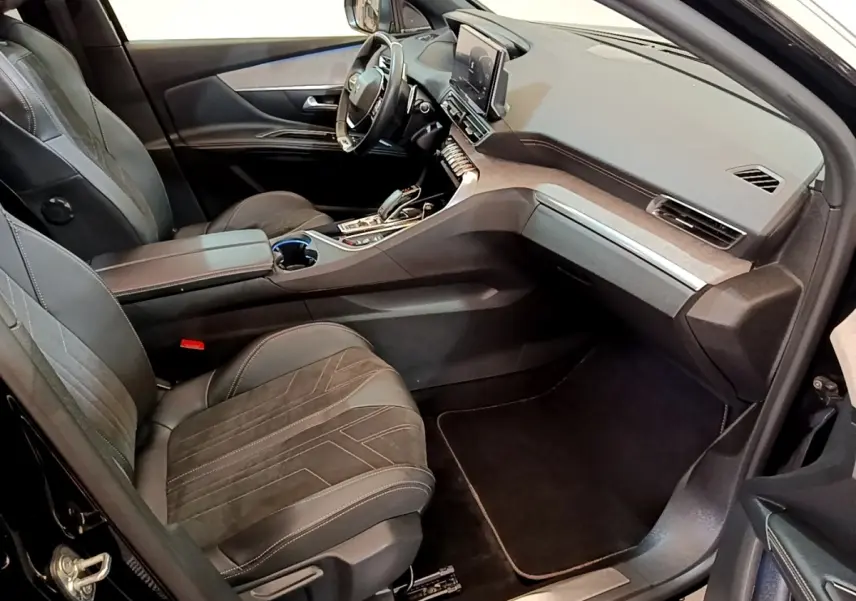 Intérieur noir du Peugeot 3008 GT Pack 2022 vu côté passager, avec tableau de bord moderne et sièges en cuir.