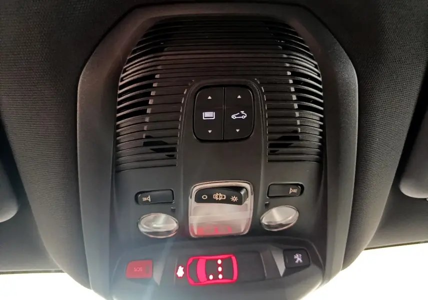 Vue en gros plan du plafonnier intérieur noir avec commandes d’éclairage et bouton SOS du Peugeot 3008 noir 2022.
